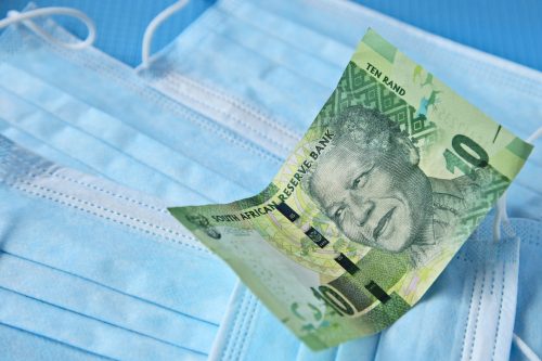 High angle shot of a banknote on some surgical masks on a blue surface para